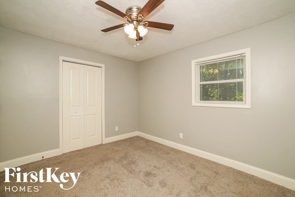 a bedroom with a ceiling fan and a white door