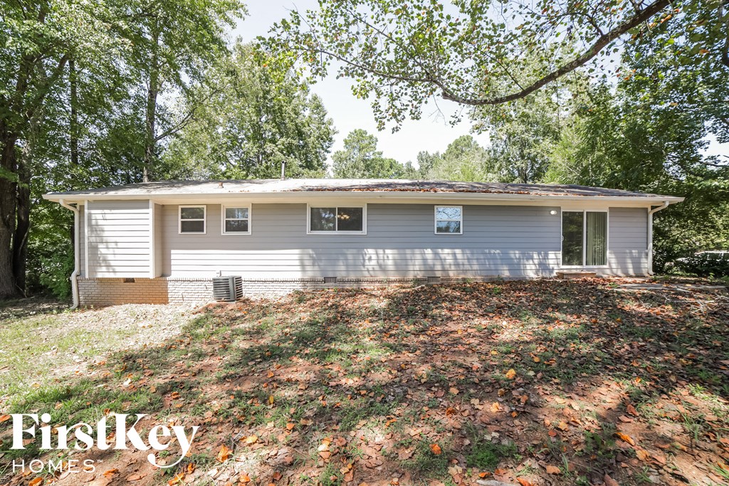 a small white house with a yard and trees