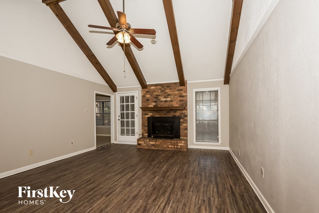 A room with a fireplace and a ceiling fan.