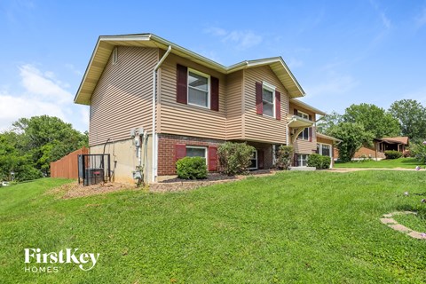 a home with a lawn and a fence in front of it