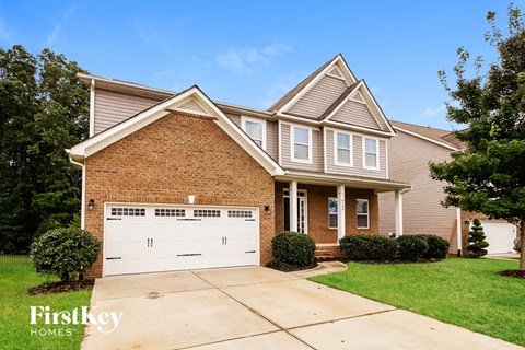 A brick house with a garage door that says Firstkey Homes.