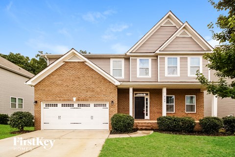 A brick house with a garage door that says "FirstKey Home".