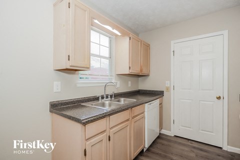 A kitchen with wooden cabinets and a white door.