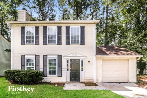 a white house with black shutters and a black front door