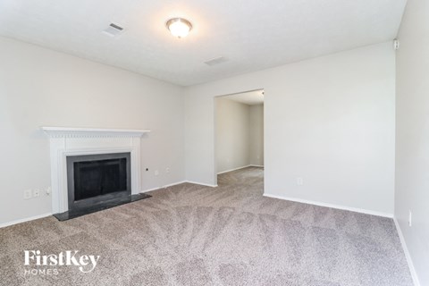 a living room with a fireplace and a carpeted floor