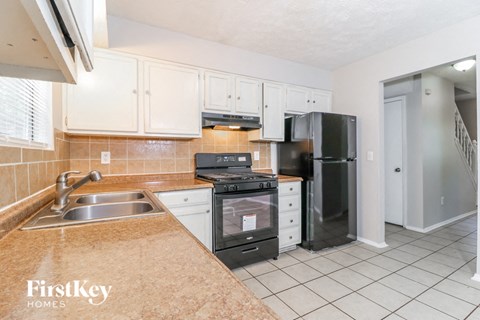 a kitchen with white cabinets and black appliances