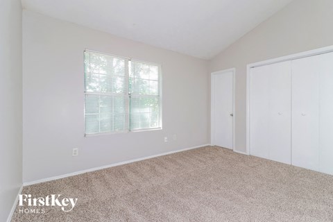the living room of a home with carpet and a window