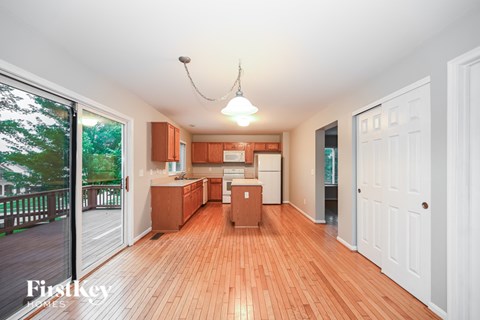 A kitchen with wooden floors and white walls.
