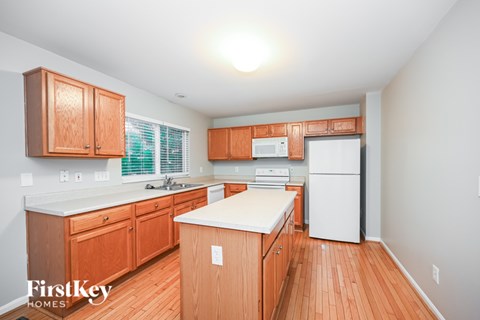 A kitchen with wooden cabinets and a white fridge.