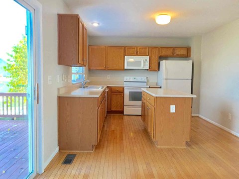 A kitchen with wooden cabinets and a white fridge.
