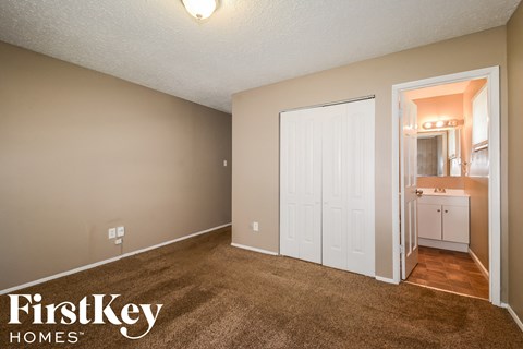 a living room with carpet and a door to a bathroom