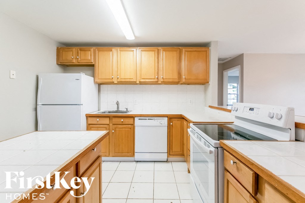 A kitchen with wooden cabinets and white appliances.