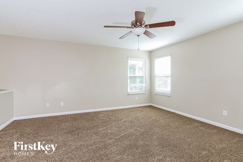 a living room with carpet and a ceiling fan