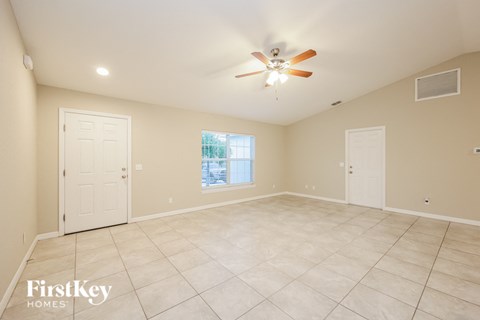 A spacious room with a ceiling fan and tile flooring.