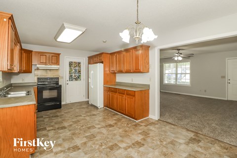 A kitchen with wooden cabinets and a tile floor.