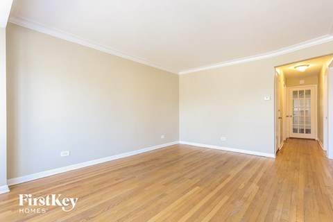 the living room of a house with wooden floors and white walls