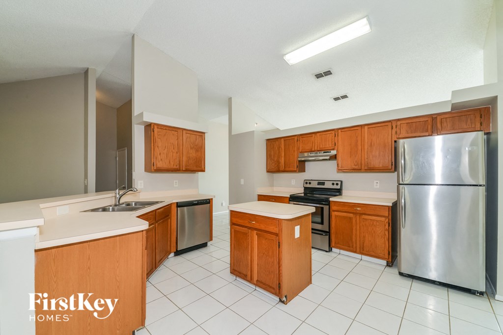 an empty kitchen with wooden cabinets and stainless steel appliances