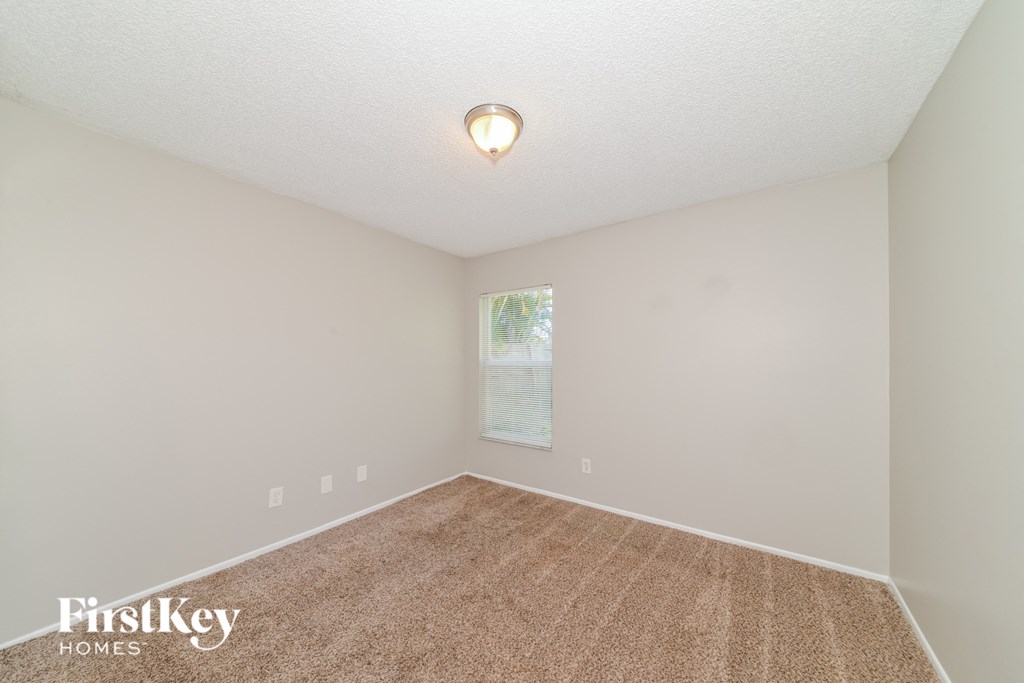 a spacious room with carpet and a window