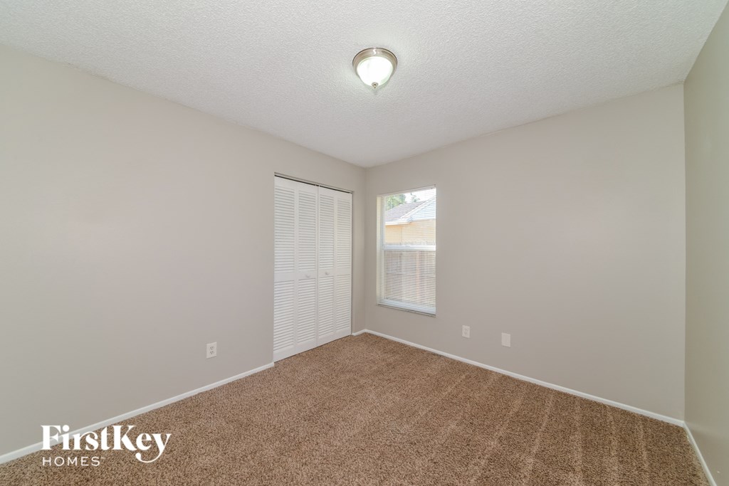a spacious living room with carpet and a large window