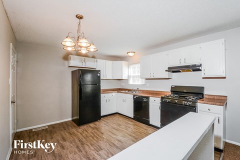 a kitchen with white cabinets and black appliances