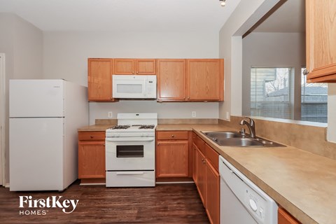 A kitchen with wooden cabinets and white appliances.