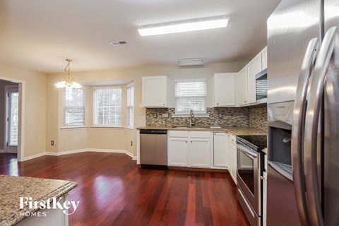 a kitchen with white cabinets and stainless steel appliances and a wood floor