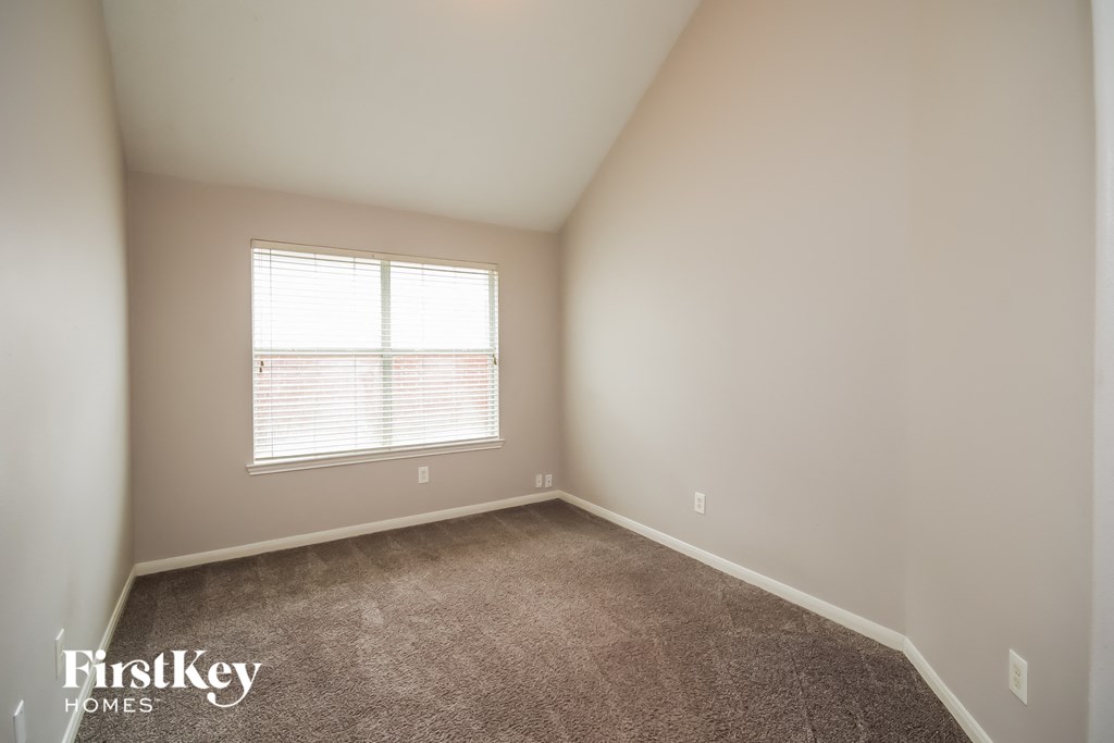 a bedroom with a window and a carpeted floor
