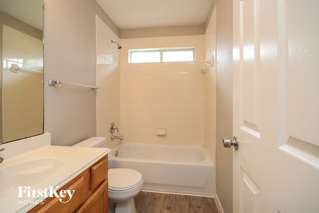 a bathroom with a toilet and a tub and a sink