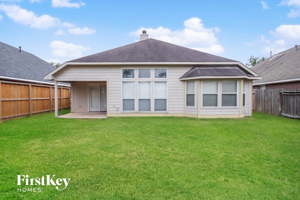 a white house with a yard and a wooden fence