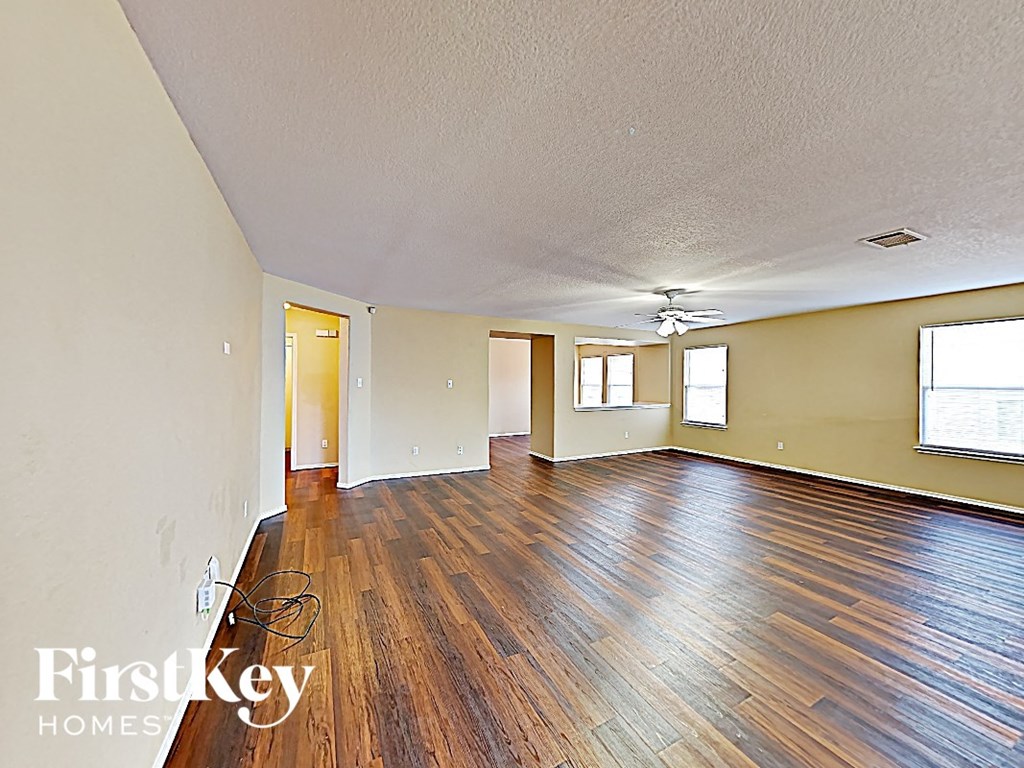 A room with wooden floors and a ceiling fan.