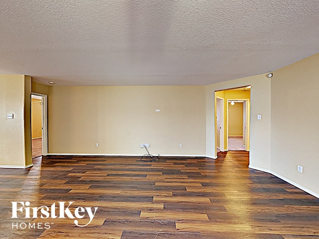 A room with wooden flooring and two doors.