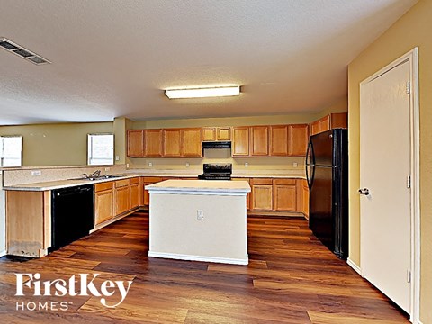 A kitchen with wooden cabinets and a white island.