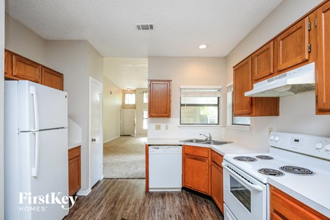 A kitchen with wooden cabinets and white appliances.