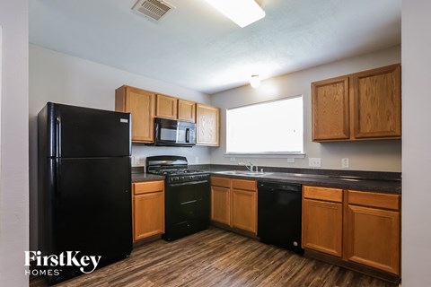 A kitchen with wooden cabinets and black appliances.