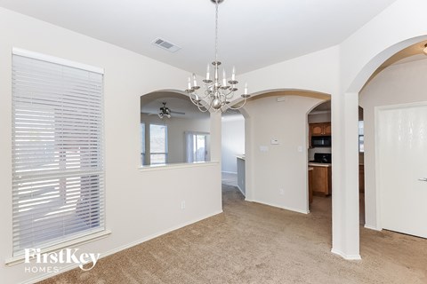 a dining room with a chandelier and a large window