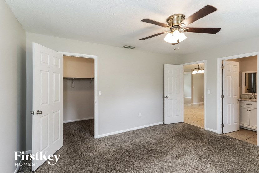 a living room with a ceiling fan and a closet