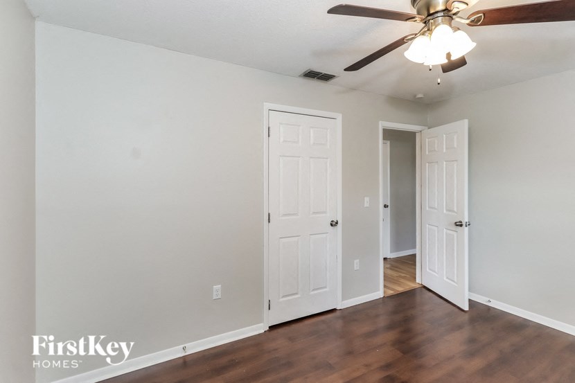the living room of an empty house with a ceiling fan