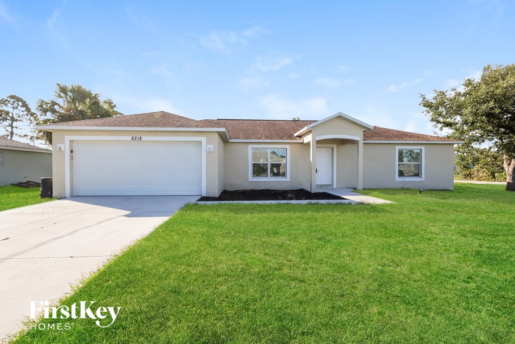 A house with a garage and a lawn in front.