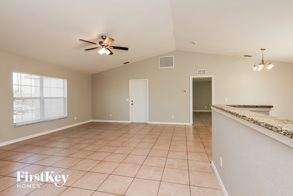 A spacious room with a ceiling fan and tiled flooring.