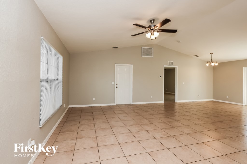 A spacious room with a ceiling fan and tile flooring.