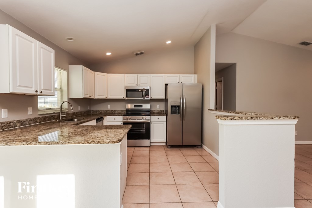 A kitchen with granite countertops and stainless steel appliances.