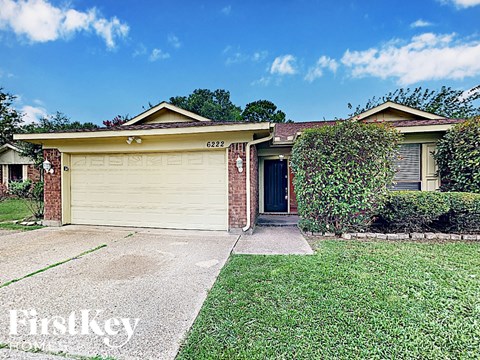 a home with a garage door and a lawn