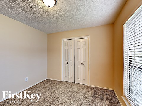 a bedroom with a white door and a window