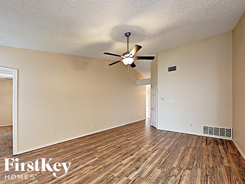 a living room with wood flooring and a ceiling fan