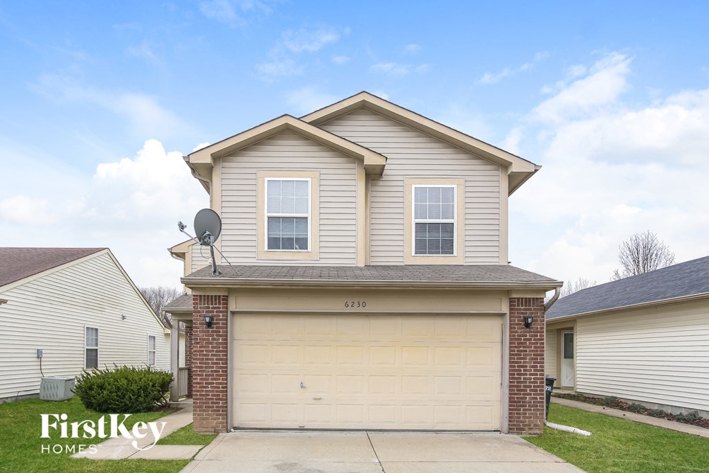 A two-story house with a garage is for sale.
