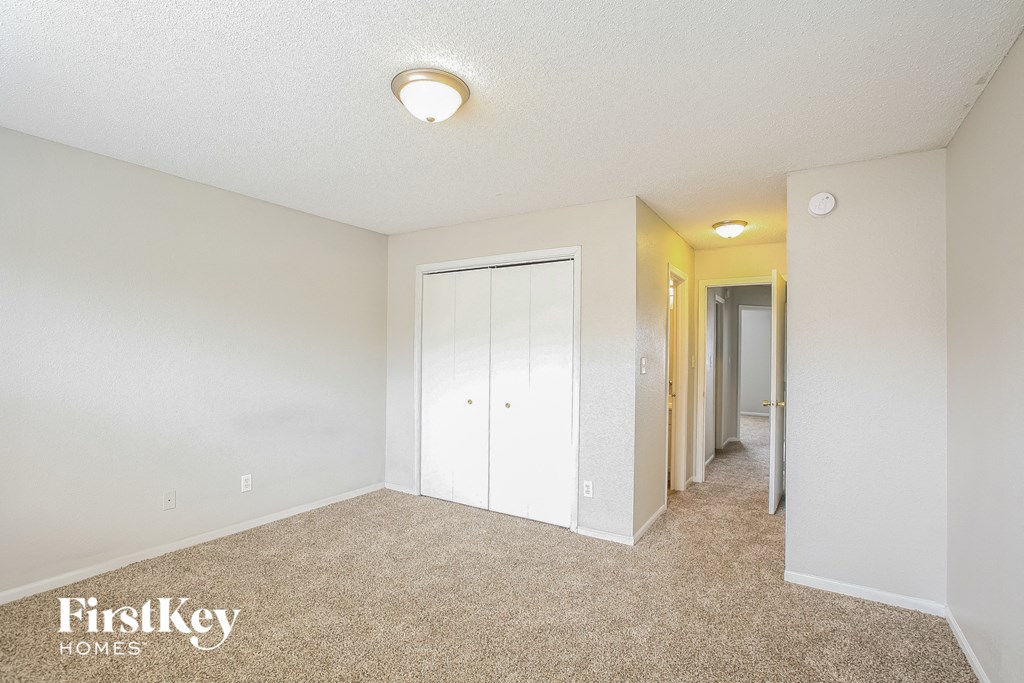 A bedroom with a carpeted floor and a white ceiling.