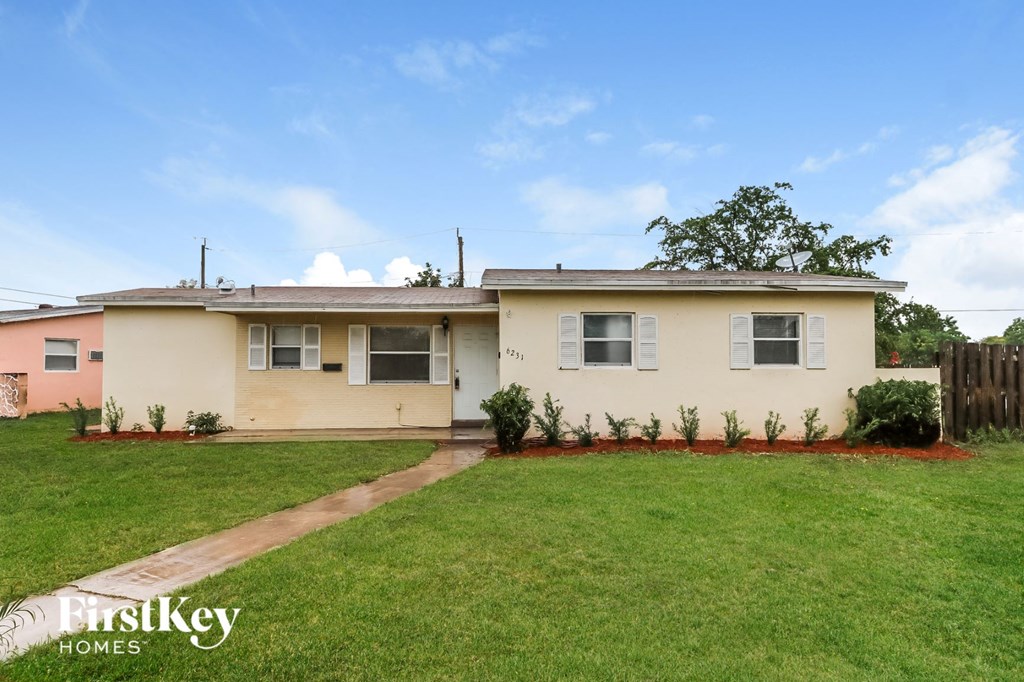 a home with a green lawn and a fence