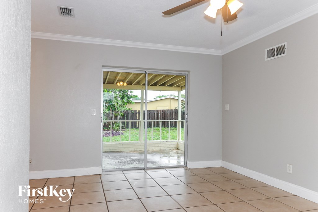 an empty living room with a sliding glass door to a patio