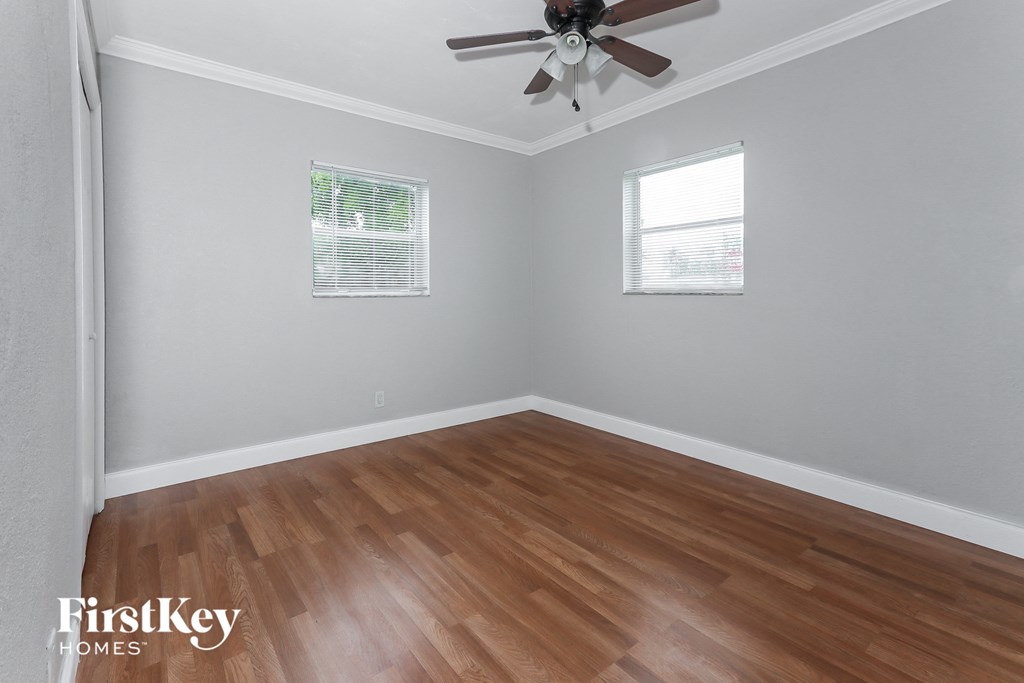 the living room with wood floors and a ceiling fan