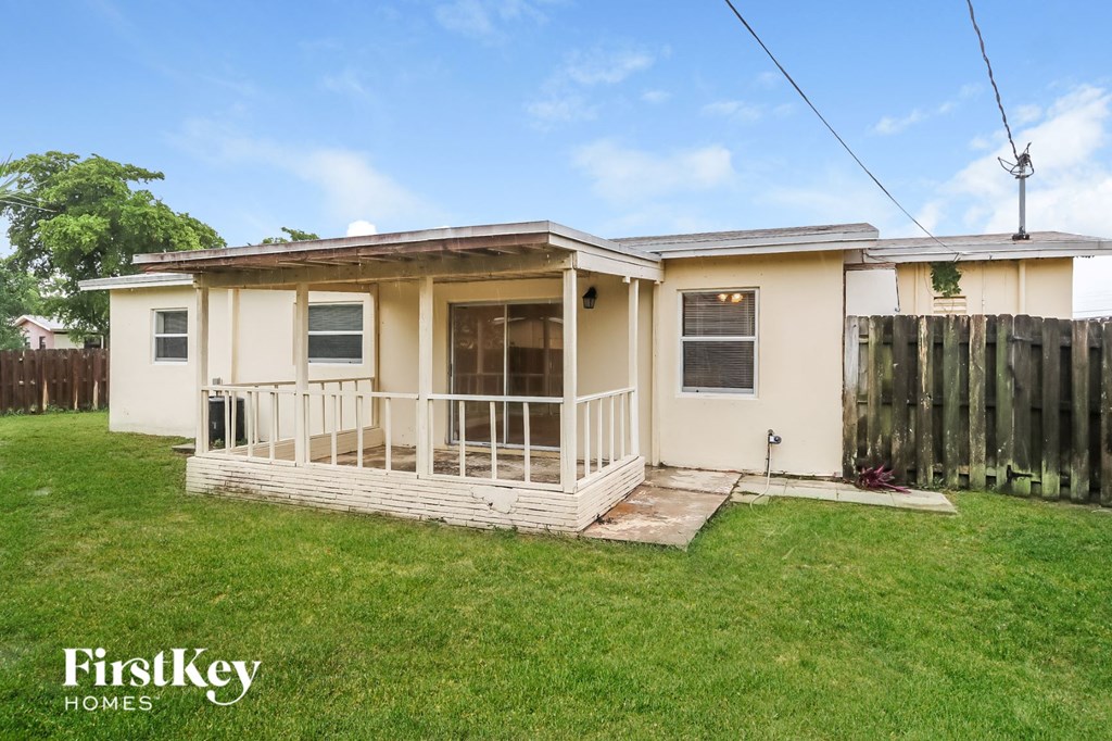 the exterior of a small house with a porch and a grass yard
